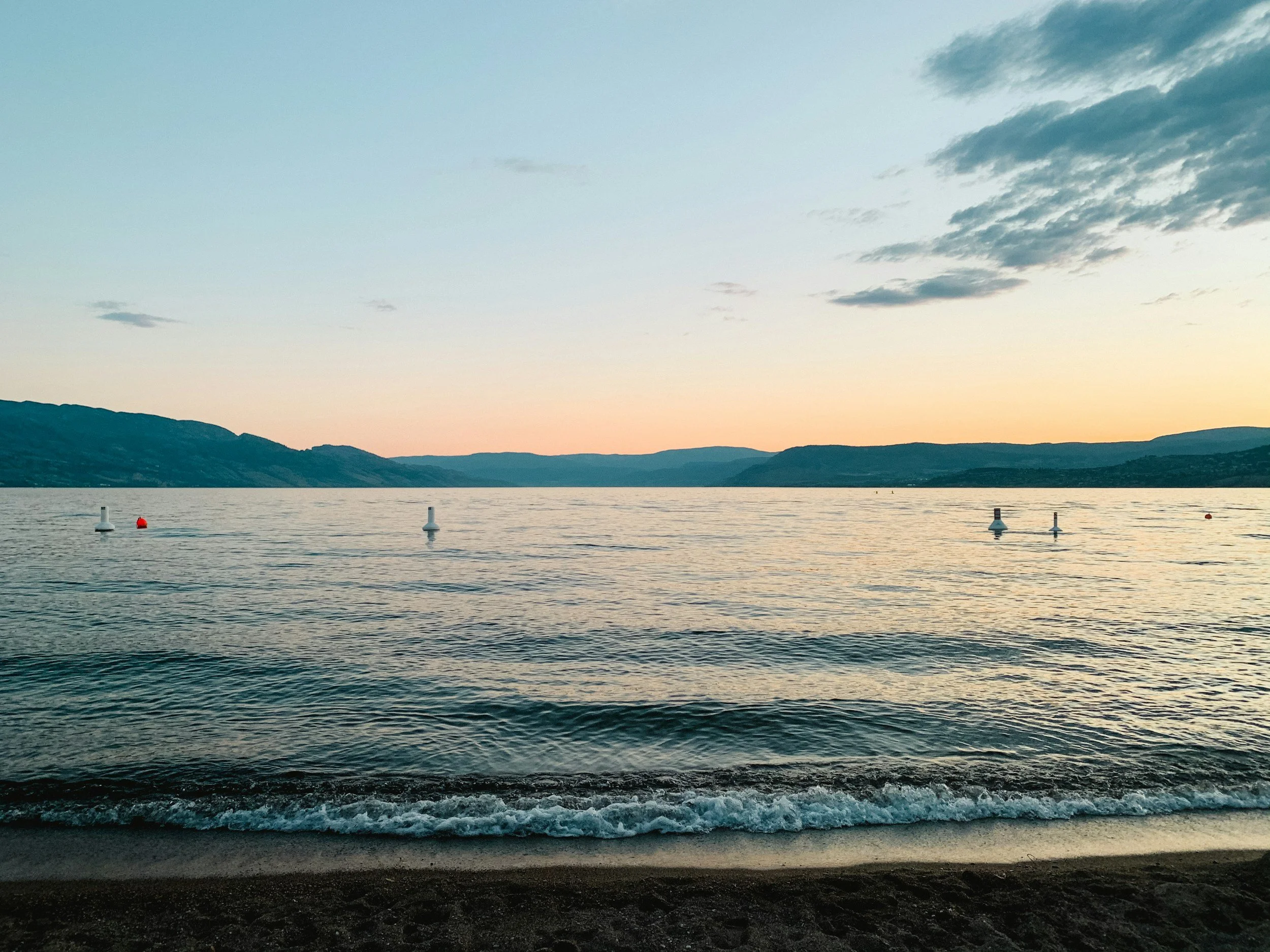 Okanagan Lake at dusk, calm water and soft mountains